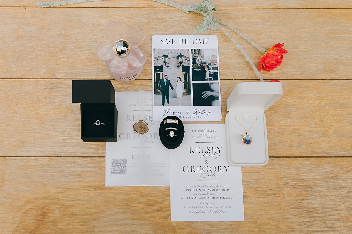 Printed wedding invitation suite flat lay with vellum wrap, wax seal, rings and save the dates